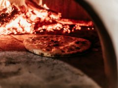 Wood fired pizza oven creating high-heat cooking conditions