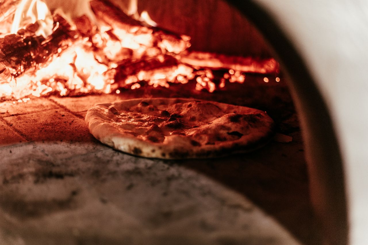 Wood fired pizza oven creating high-heat cooking conditions